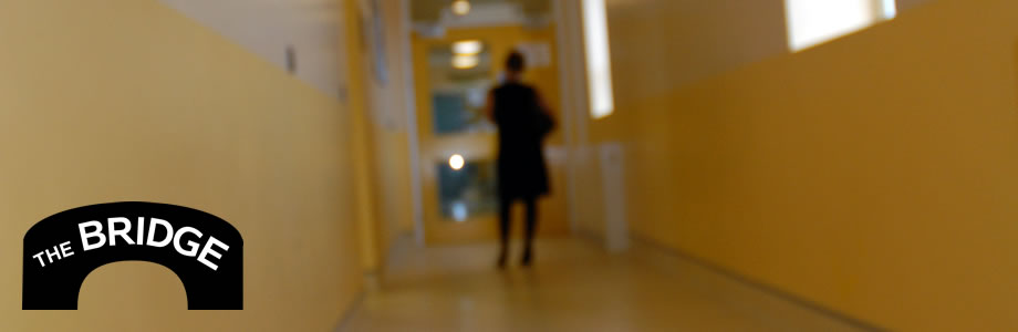 A blurred image of a woman standing in a corridor